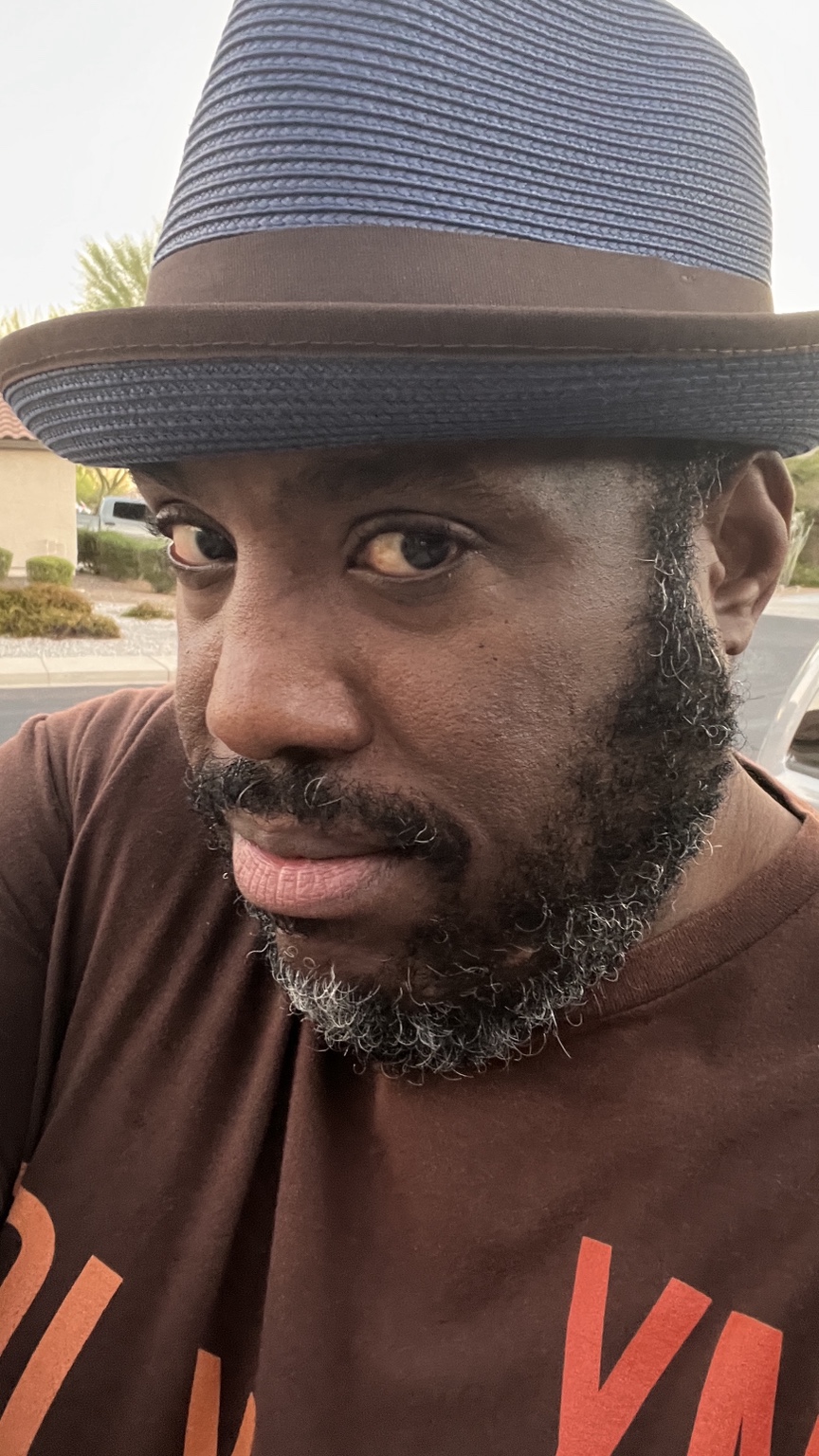 Brian E. Johnson outdoors in a gray fedora